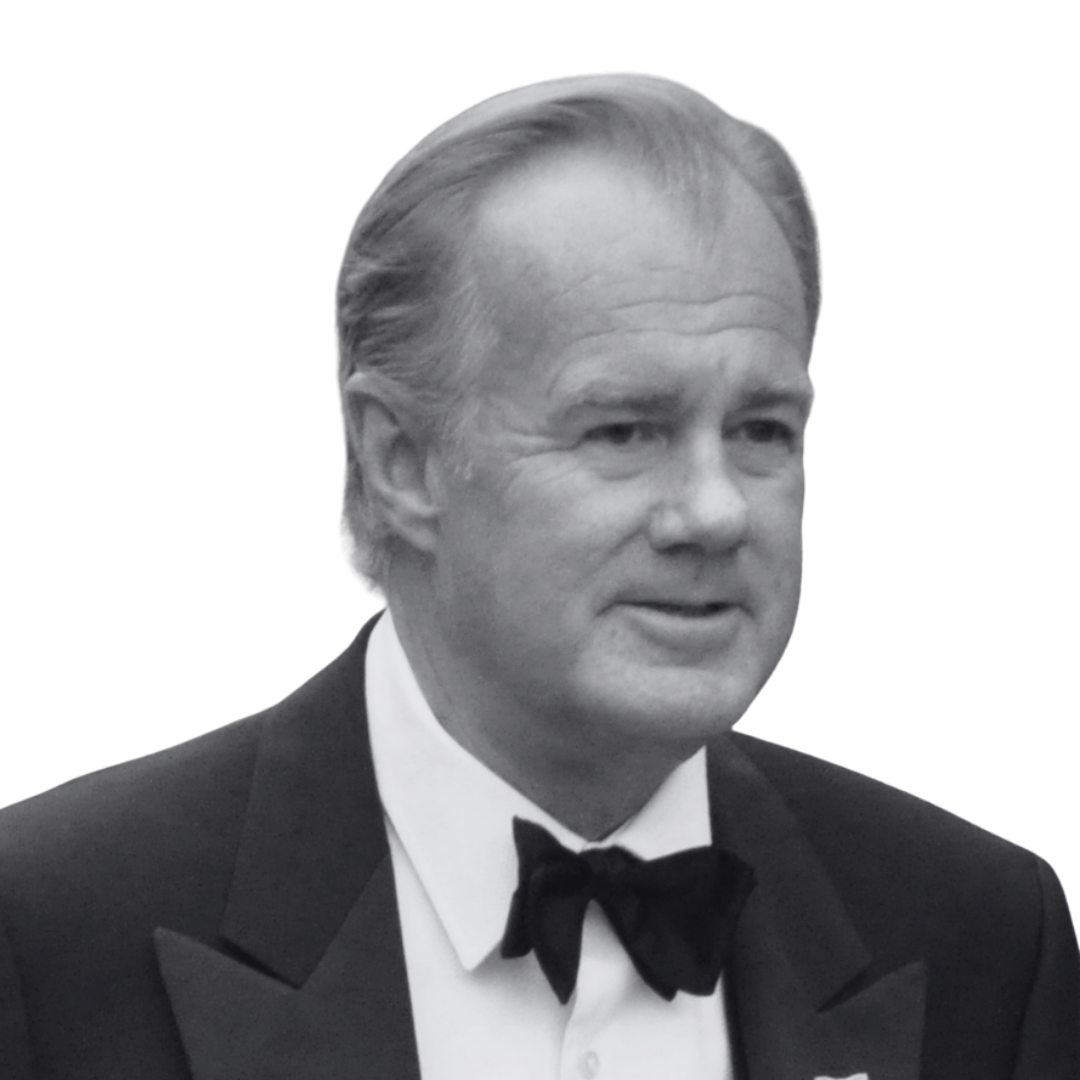 A black-and-white photo of a man in a tuxedo with a bow tie, smiling.
