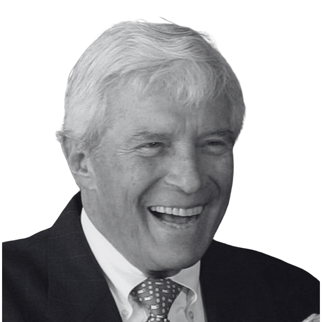 Black and white photo of a smiling older man with gray hair, dressed in a suit and tie.