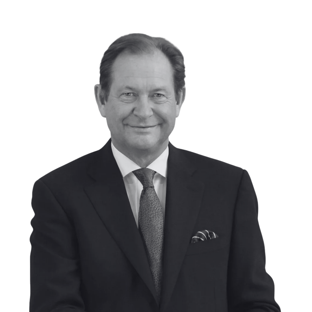 Black and white photo of a smiling man in a suit with a tie and pocket square.