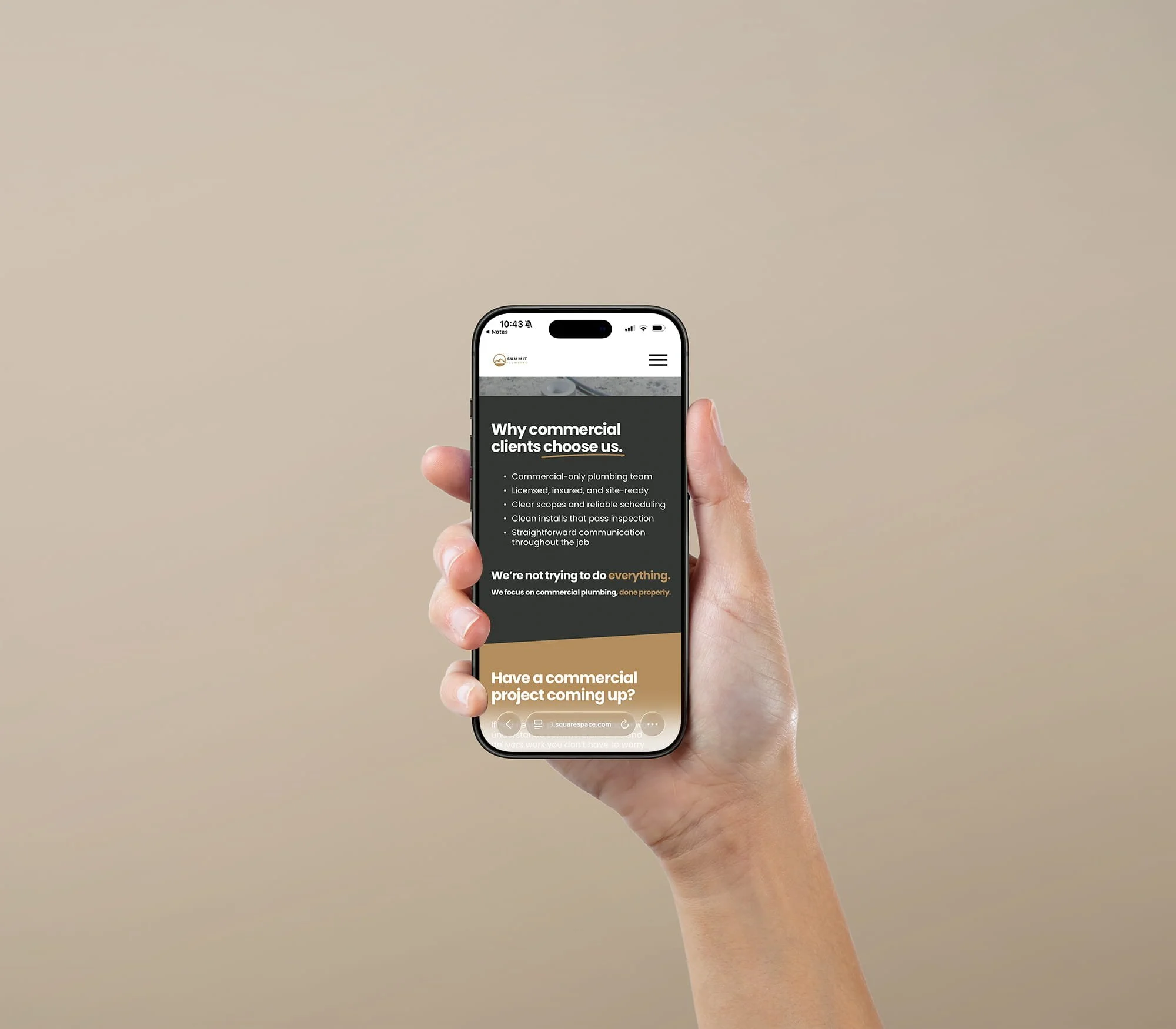 Hand holding an iPhone mockup featuring the homepage of a plumbing tradie website designed to generate enquiries.