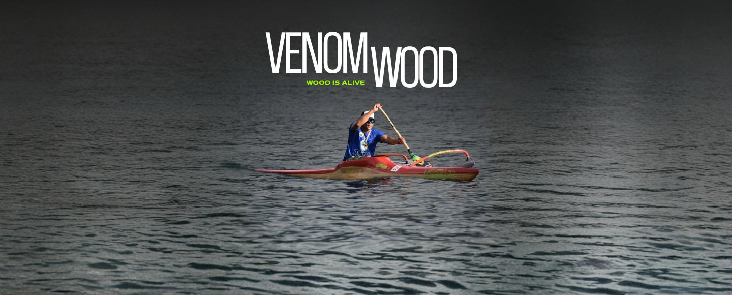 Une personne en pirogue sur un lac, portant un T-shirt bleue et un casquette, avec le texte "VENOM WOOD" et "WOOD IS ALIVE" en surimpression.