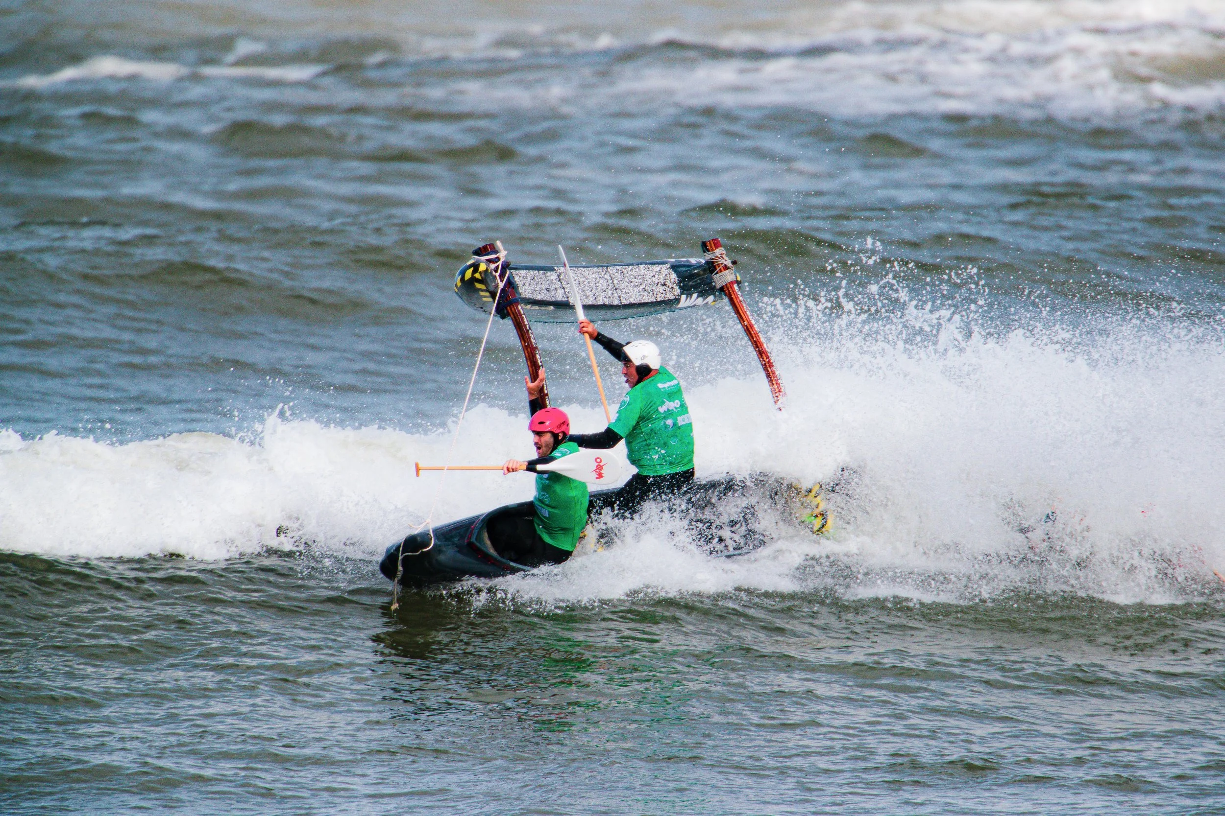 équipage de pirogue hawaïenne OC4 surf en train de faire un huli dans une vague