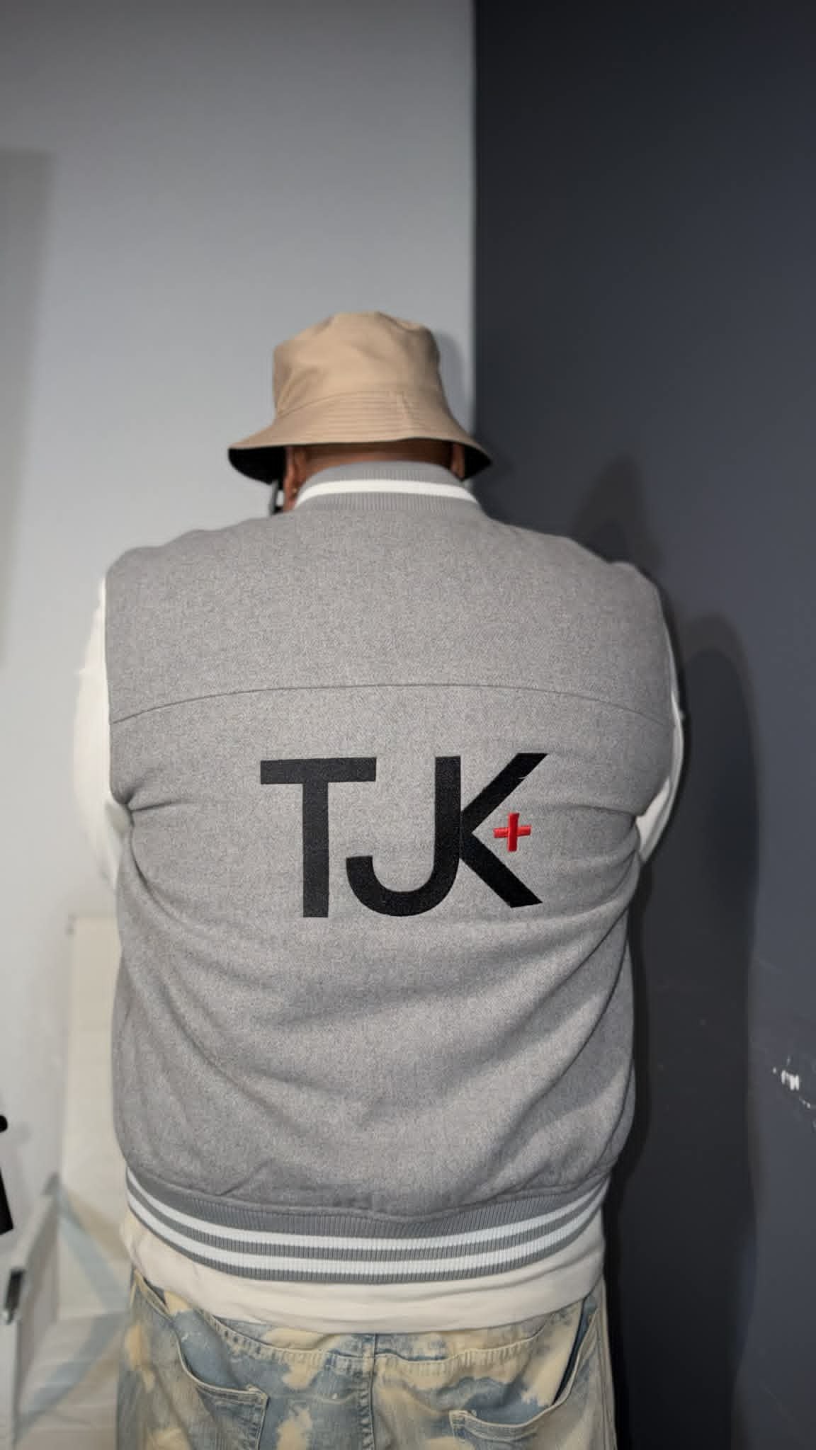 Jamez T. director, producer and owner of TJK plus sporting a gray and white jacket with the brand's logo on the back