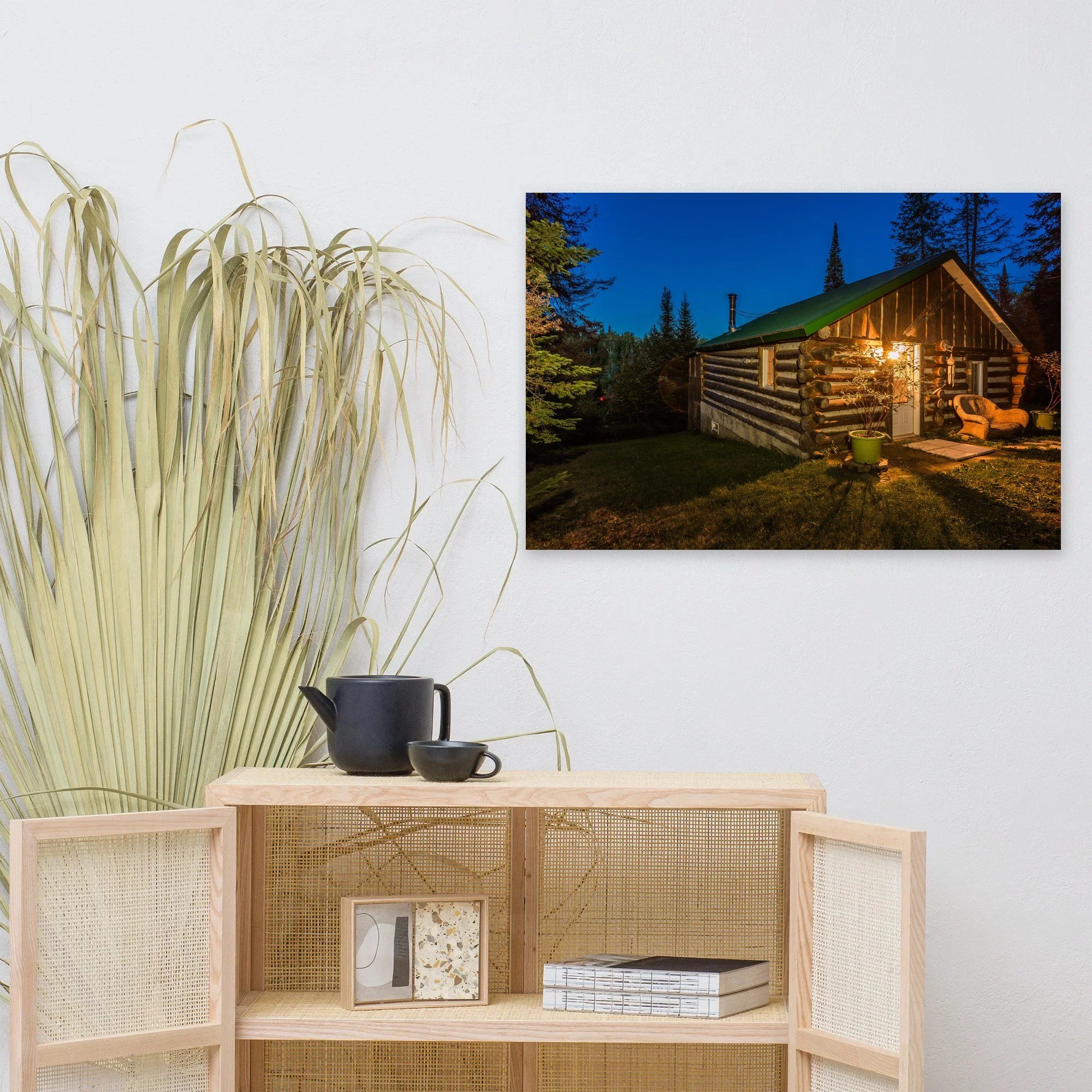 Affiche Le chalet en bois rond, à la tombée de la nuit au mur au-dessus d'un meuble en bois clair – tirage photo d'art de Guillaume Gorini