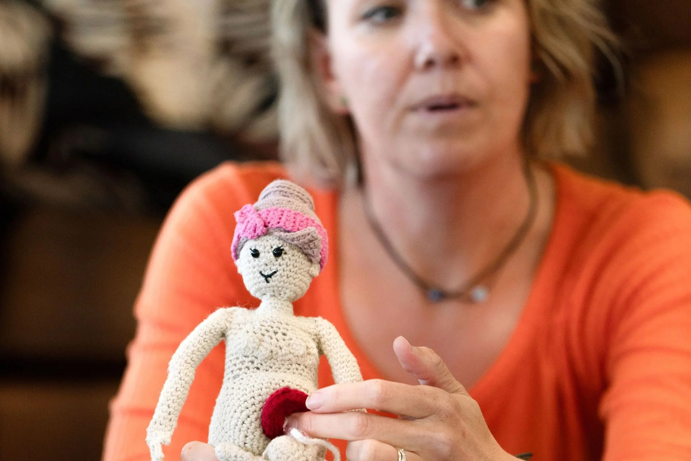 Sarah Drawwater holding a crochet'd woman to help demonstrate how birth works