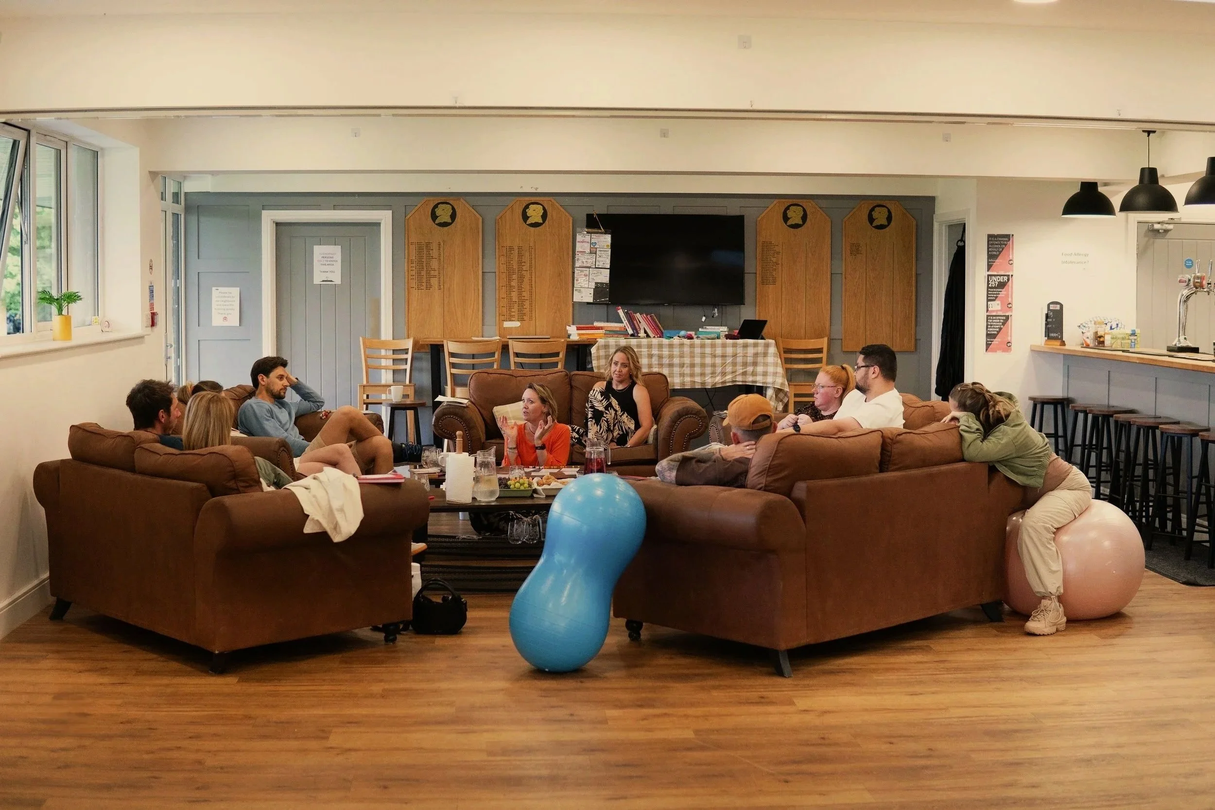 Pregnant parents sitting on a sofa in a warm settlng
