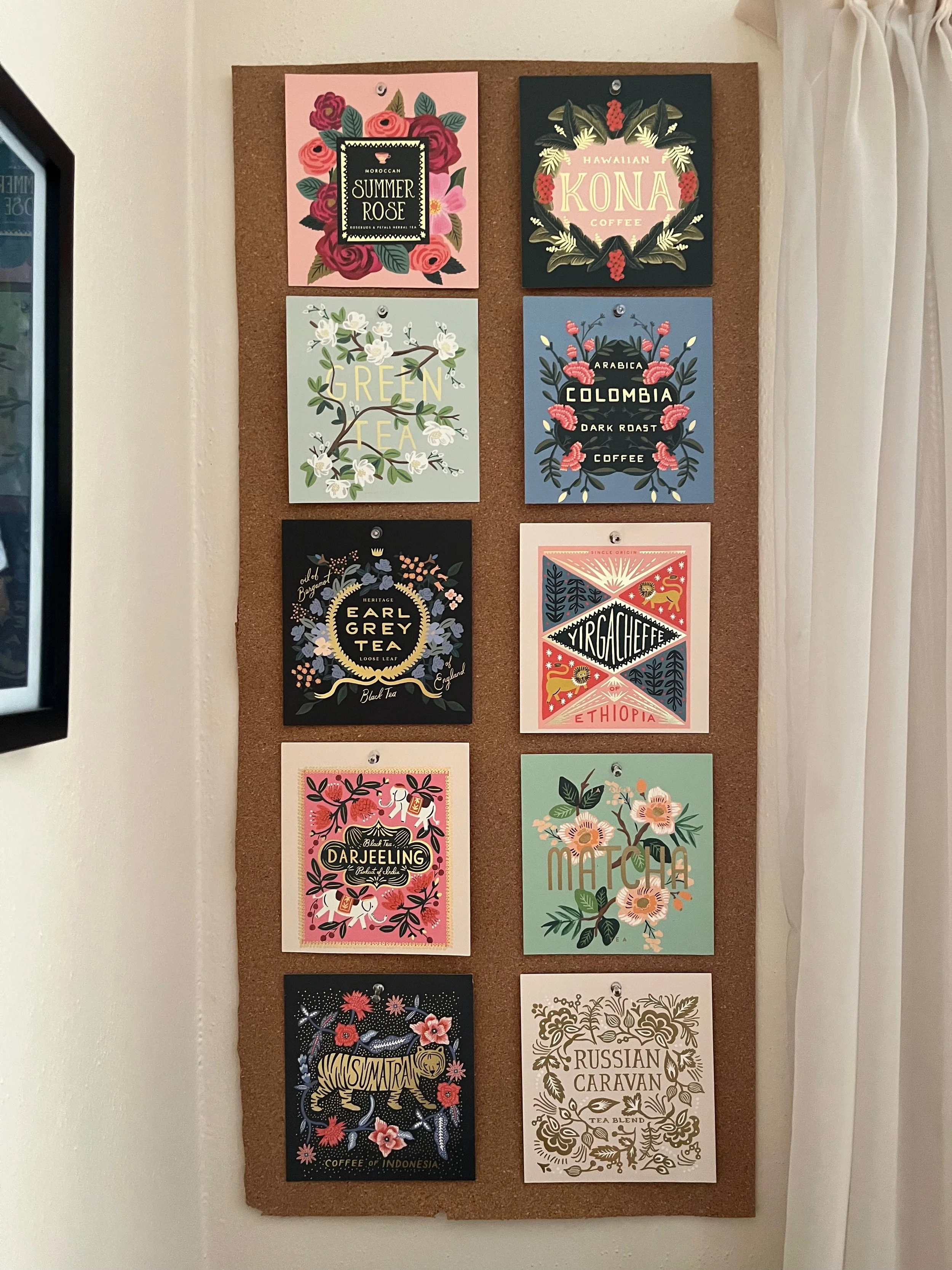 Collection of nine colorful illustrated tea and coffee packaging designs pinned to a corkboard, labeled with various tea and coffee types and origins.