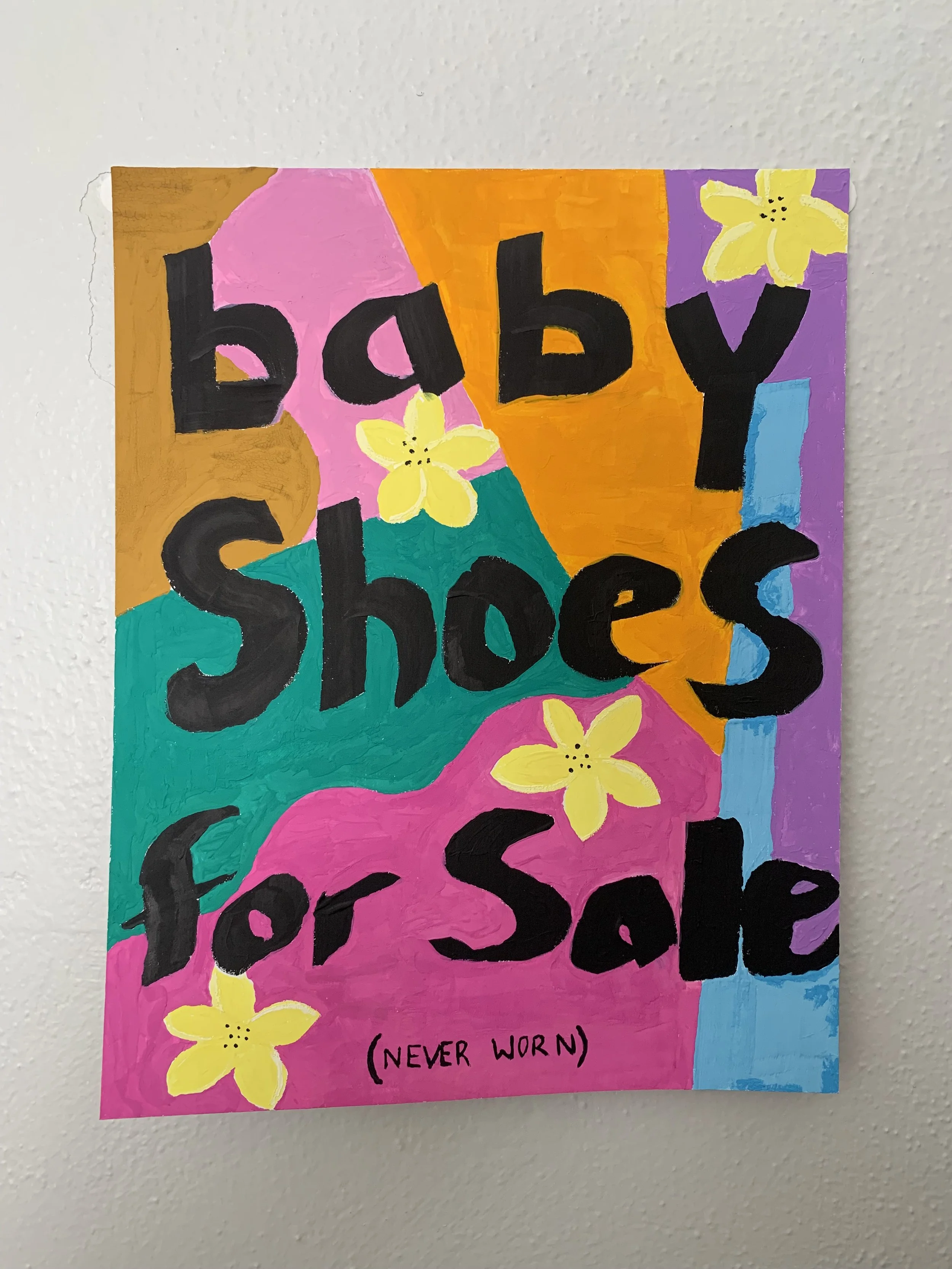 Colorful poster with hand-painted text reading 'baby shoes for Sale' and small yellow flowers, featuring a patchwork of pink, orange, blue, purple, and green background sections, with a note '(Never Worn)' at the bottom.