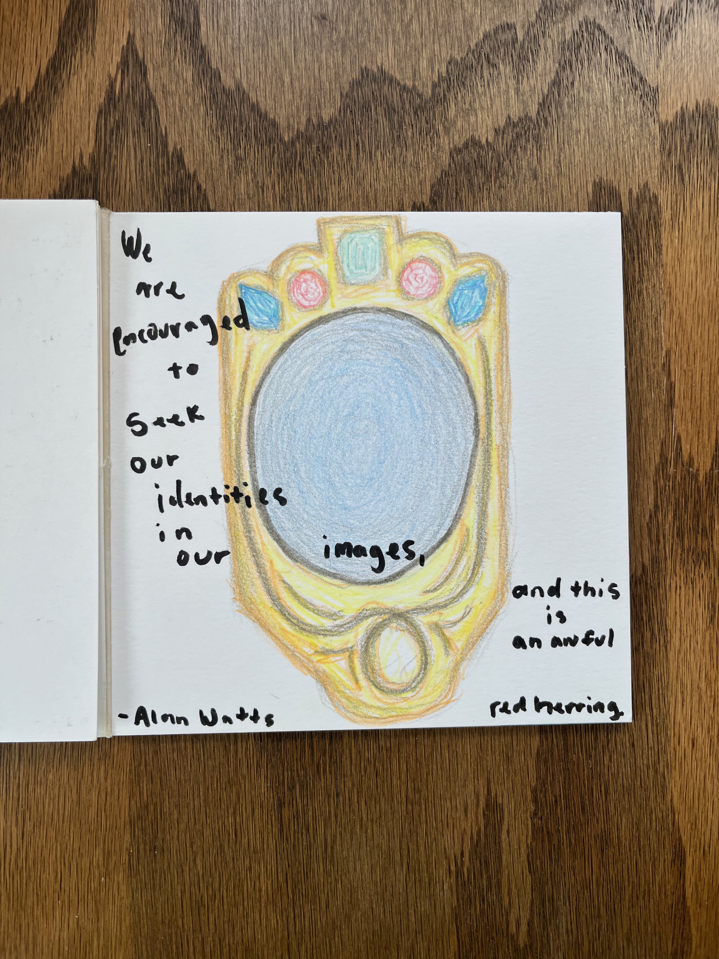 Colorful sketch of a ring or medallion with a large central oval area, surrounded by decorative elements in pink, blue, yellow, and green. Handwritten text around the drawing reads, "We are programmed to seek our identities in our images, and this is