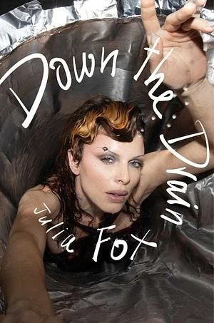 A woman with wavy hair taking a selfie inside a large metal container with the words "Down the Jimm" written on it.