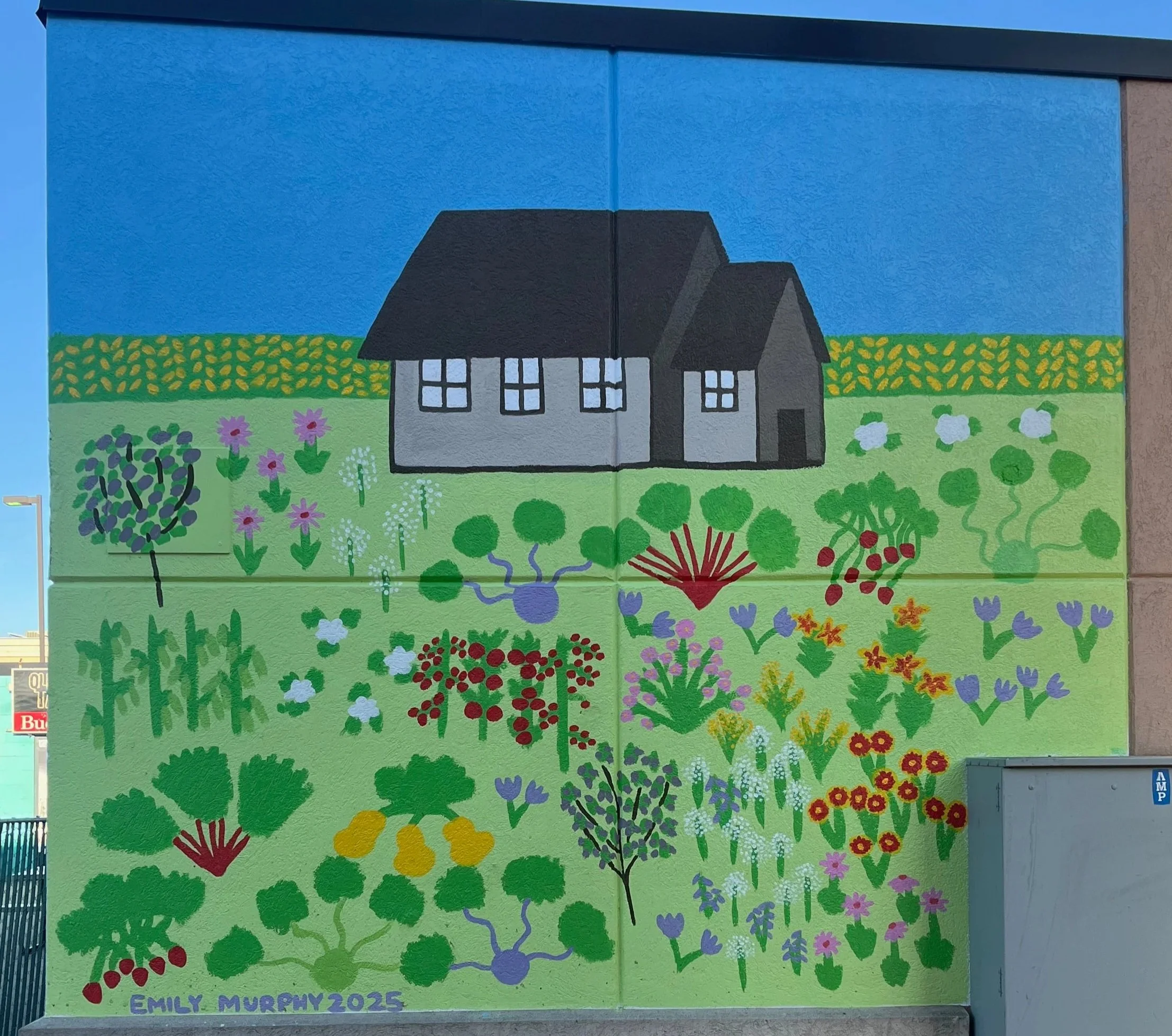 Colorful mural of a house with a black roof, surrounded by various painted flowers and plants on a blue sky background