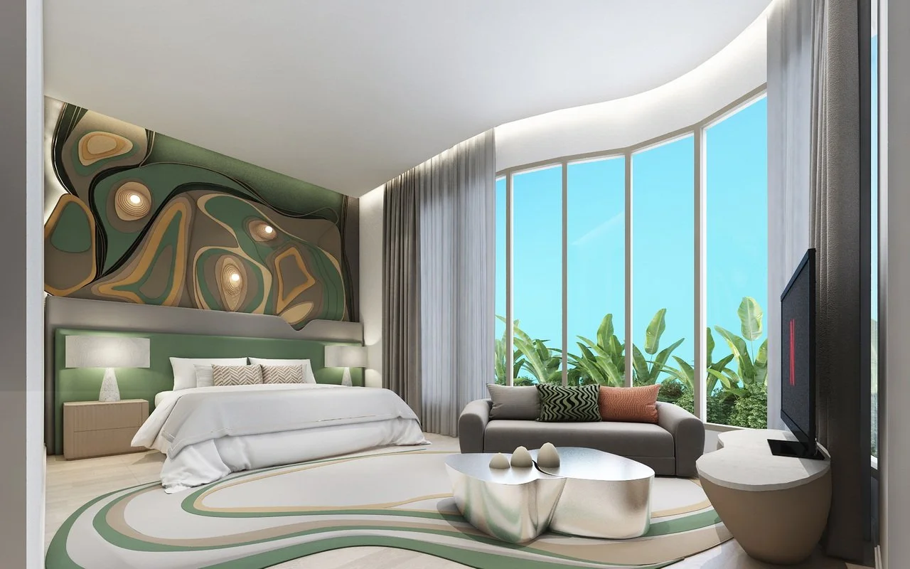 Modern hotel bedroom with large bay window, a bed with white linens and decorative pillows, a sofa with cushions, a contemporary coffee table, and abstract wall art.