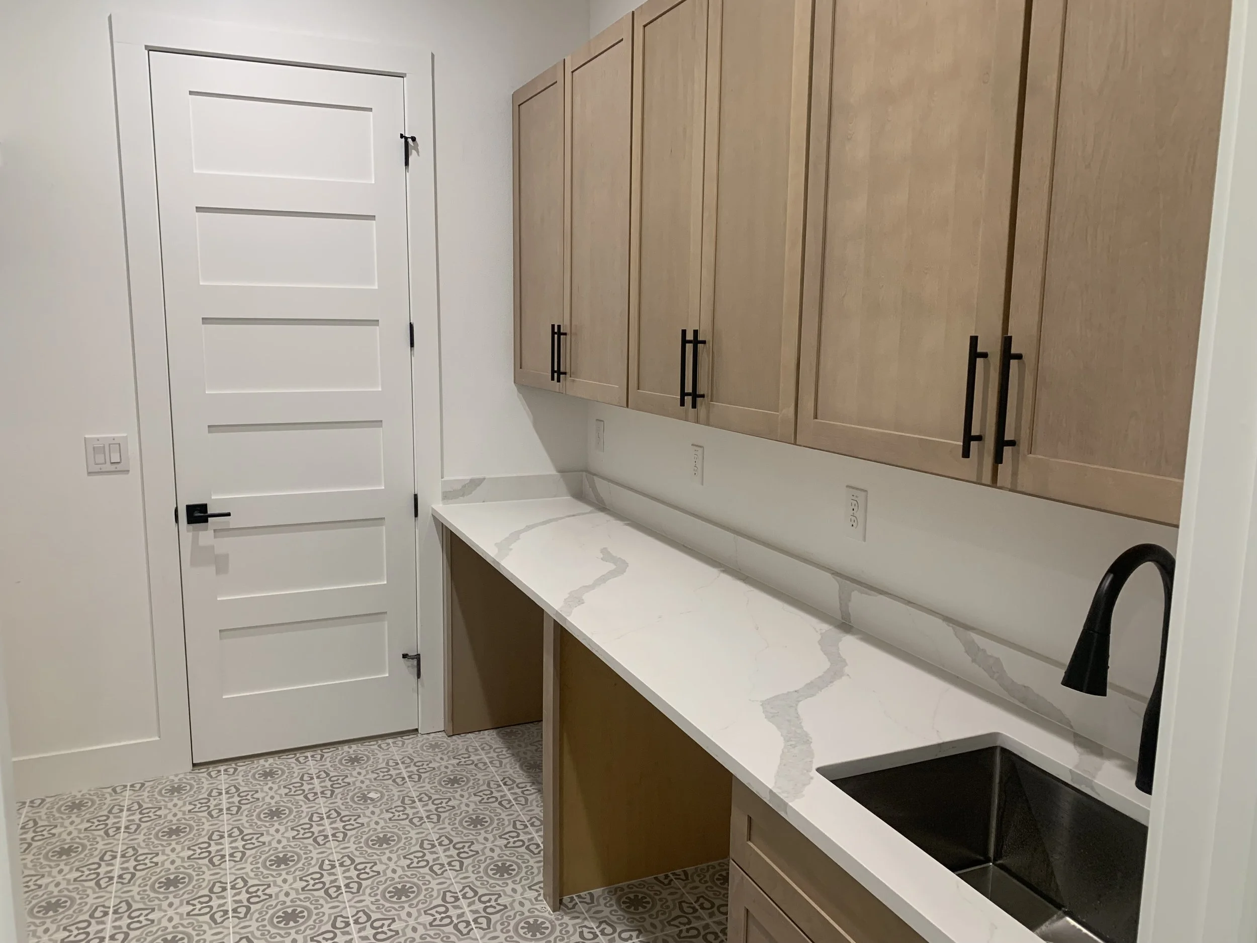Custom utility room, complete with a deep sink and space for storage under countertops