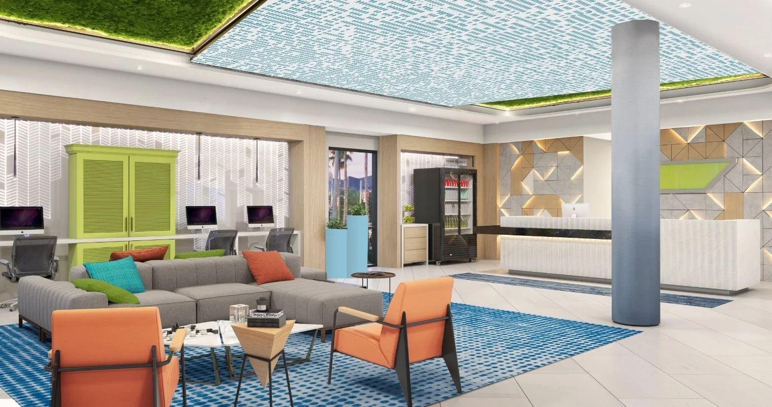A modern lobby in Orlando with a gray sectional sofa, orange chairs, and a blue patterned rug. The ceiling features green and blue accents. A reception desk and computer workstations are in the background, with geometric wall designs and vibrant déc