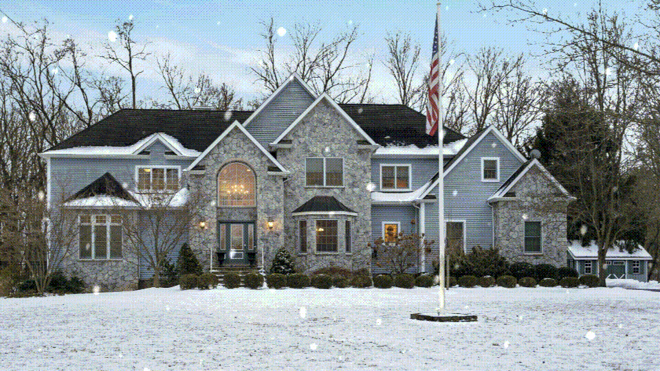 home at twilight with snow falling