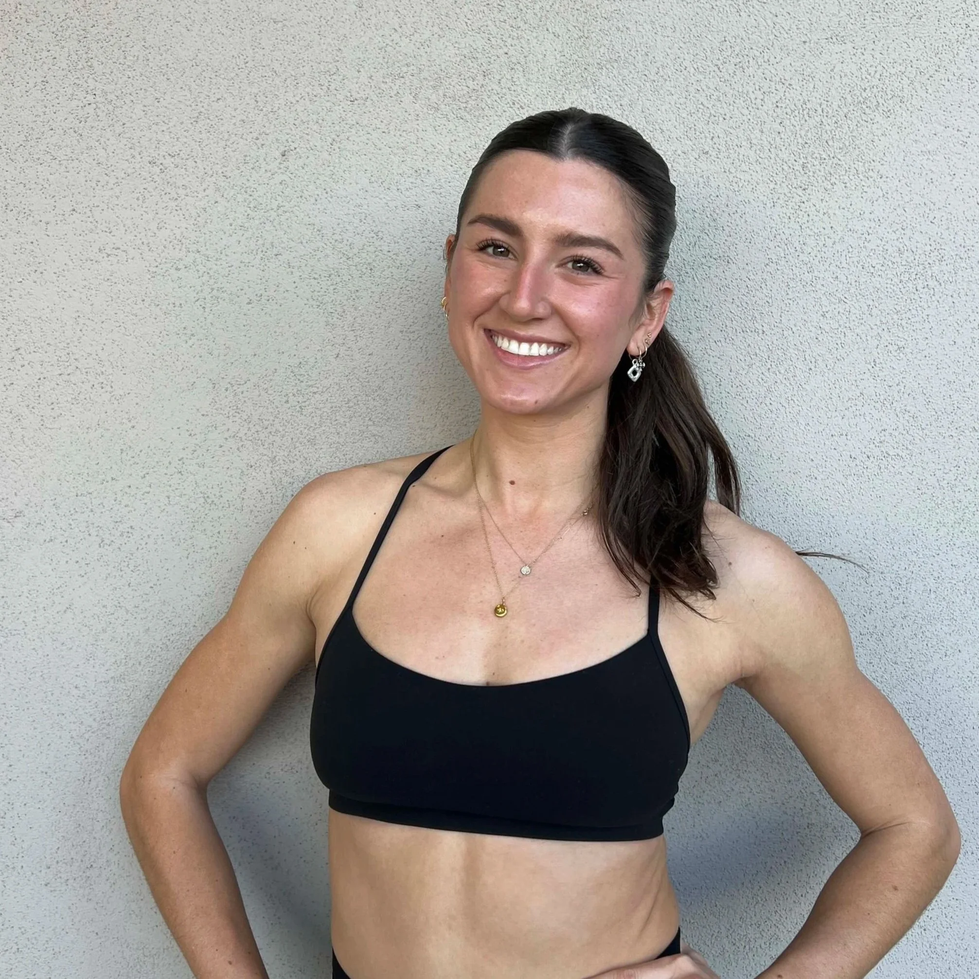 Indoor cycling studio with numerous stationary bikes, illuminated by pink and blue LED ceiling lights, creating a vibrant atmosphere.