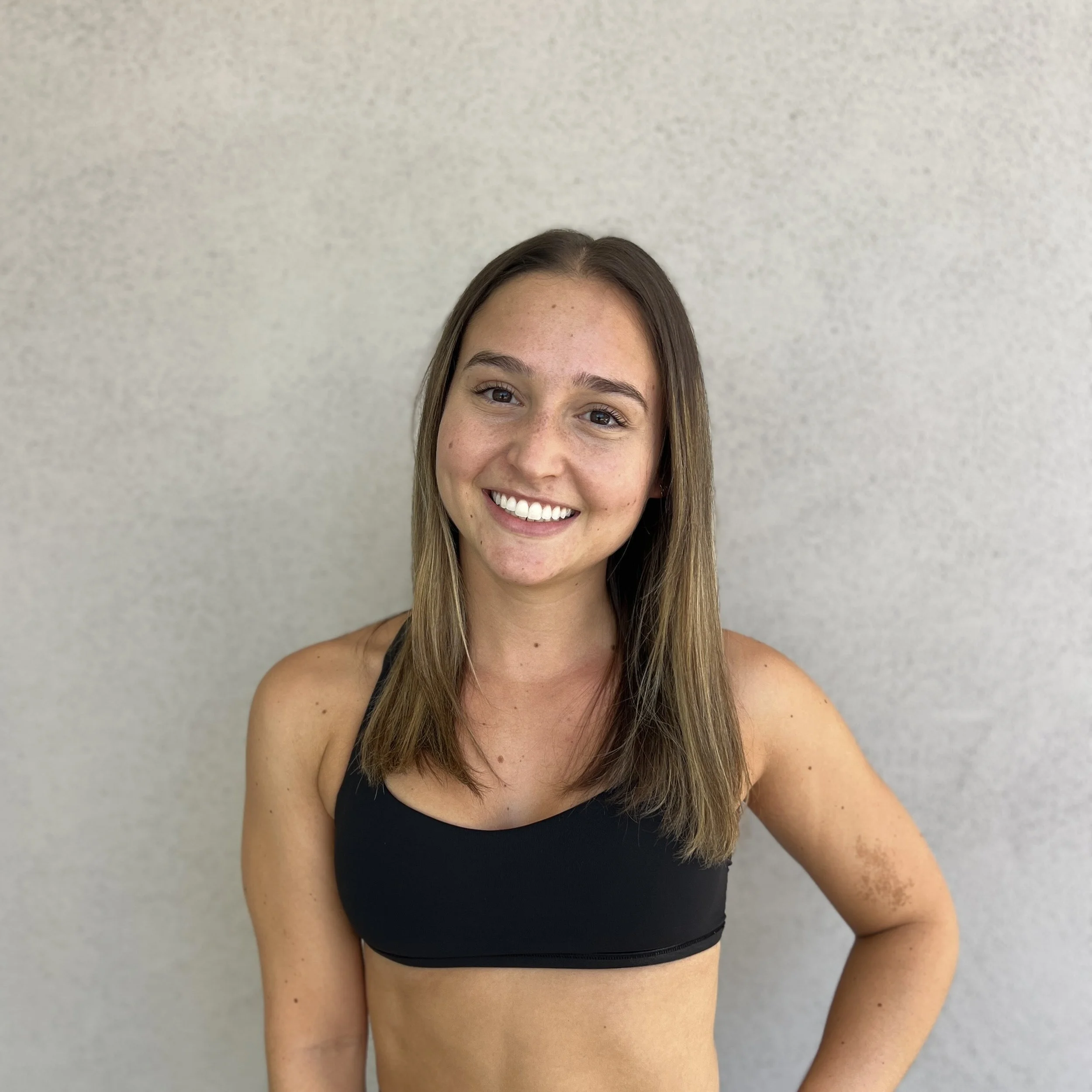 Indoor cycling studio with exercise bikes under purple LED lights on the ceiling.