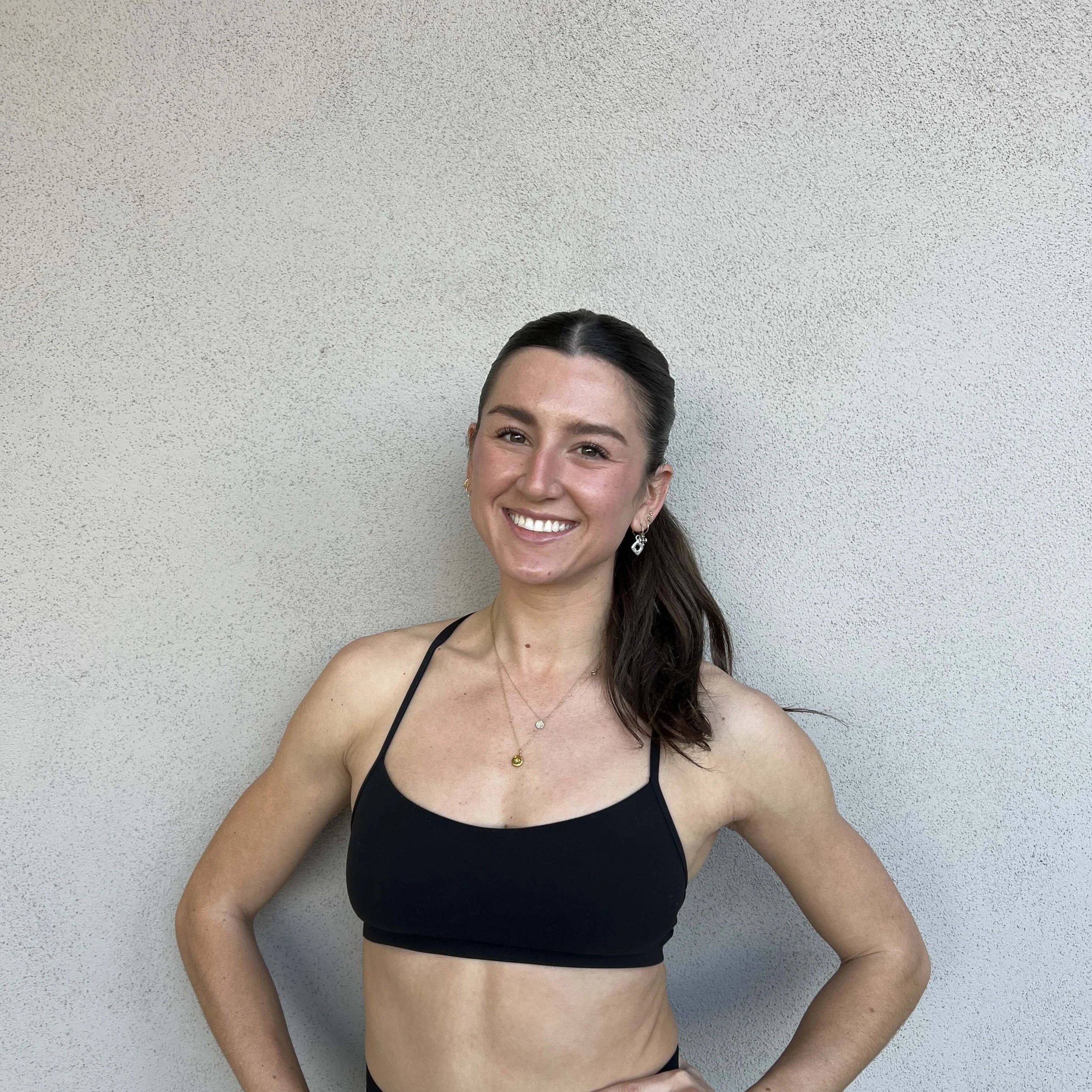 Indoor cycling studio with numerous stationary bikes, illuminated by pink and blue LED ceiling lights, creating a vibrant atmosphere.