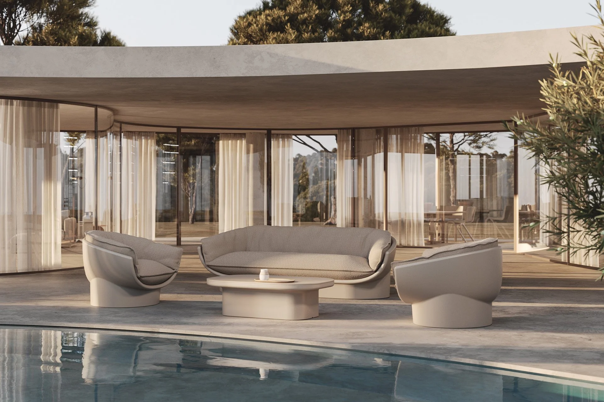 Área de descanso con sillones modernos y mesa junto a una piscina, con fondo de cristaleras y cortinas, y árboles en el exterior