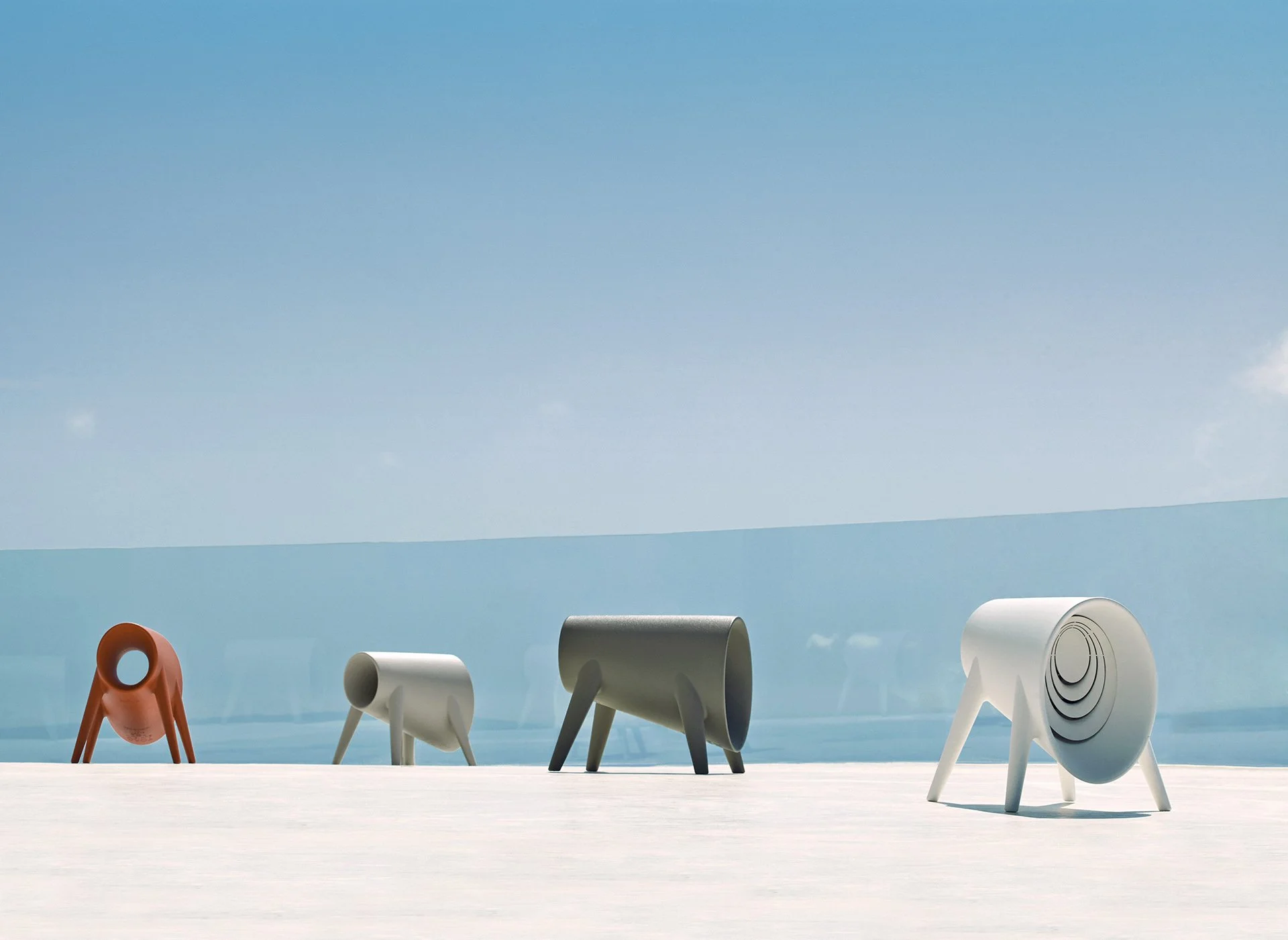 Cuatro esculturas modernas con forma de animales, en una terraza junto a una piscina y un cielo despejado