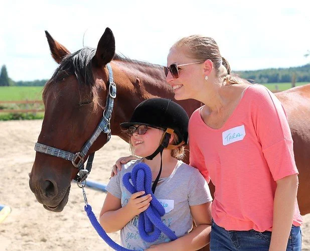 Child and Facilitator with relaxed horse.jpg