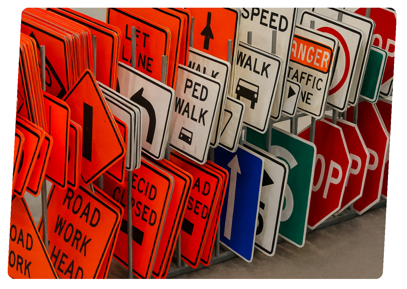 A large collection of various road and traffic signs, including warning, speed, and regulatory signs, arranged on display racks.