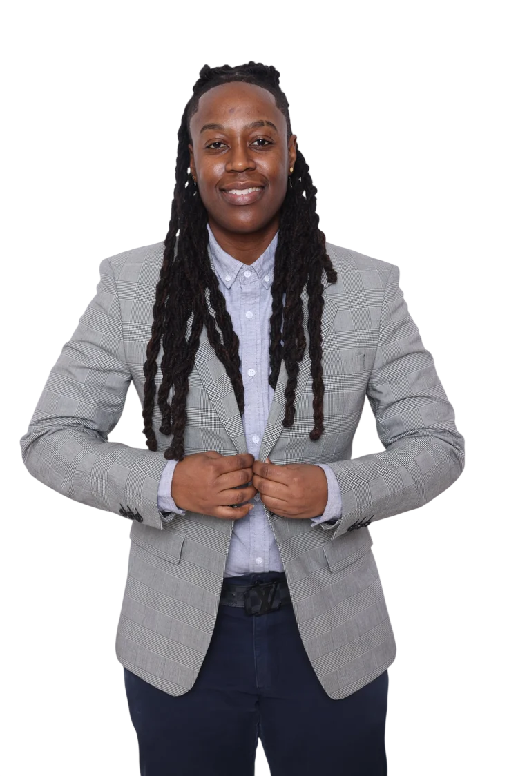 A confident African American woman wearing a checked gray blazer over a light blue button-up shirt, standing with her hands in front of her.