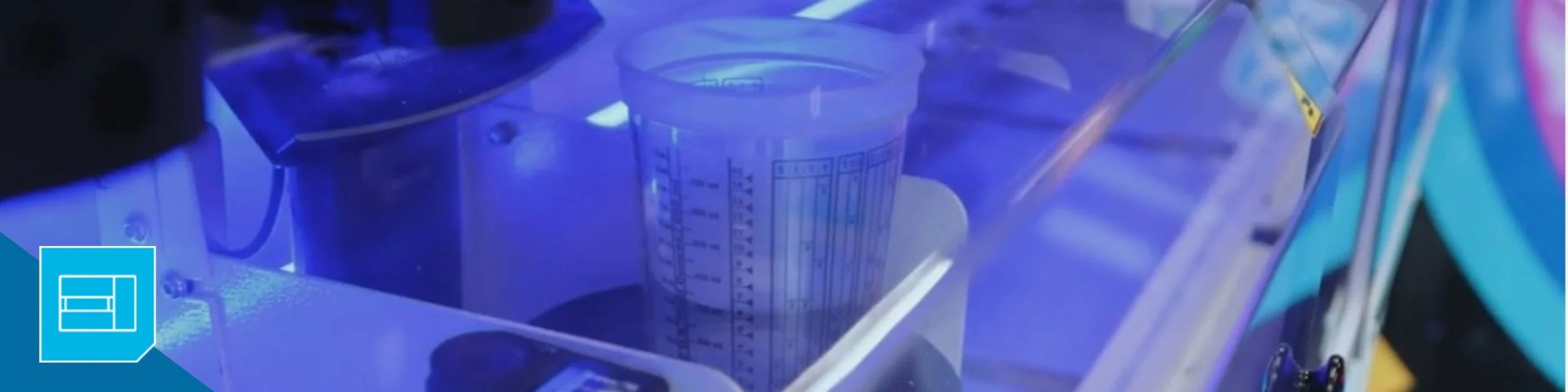 A paint cup sits on the PPG MoonWalk automated mixing system dispensing automotive paint from a paint formula.