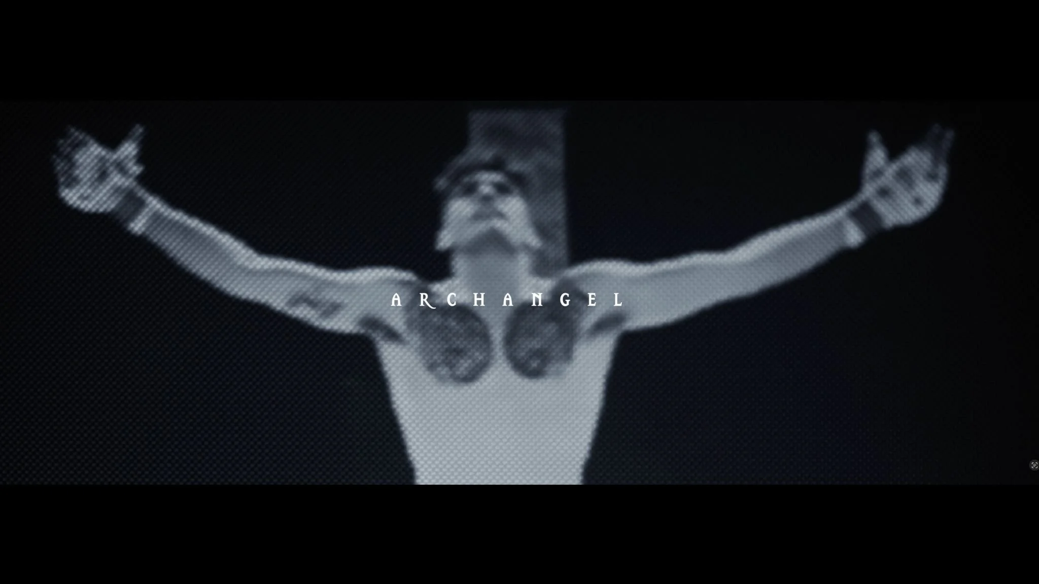 Black and white image of a person with arms outstretched, wearing glasses, with the word 'ARCHANGEL' over the chest.