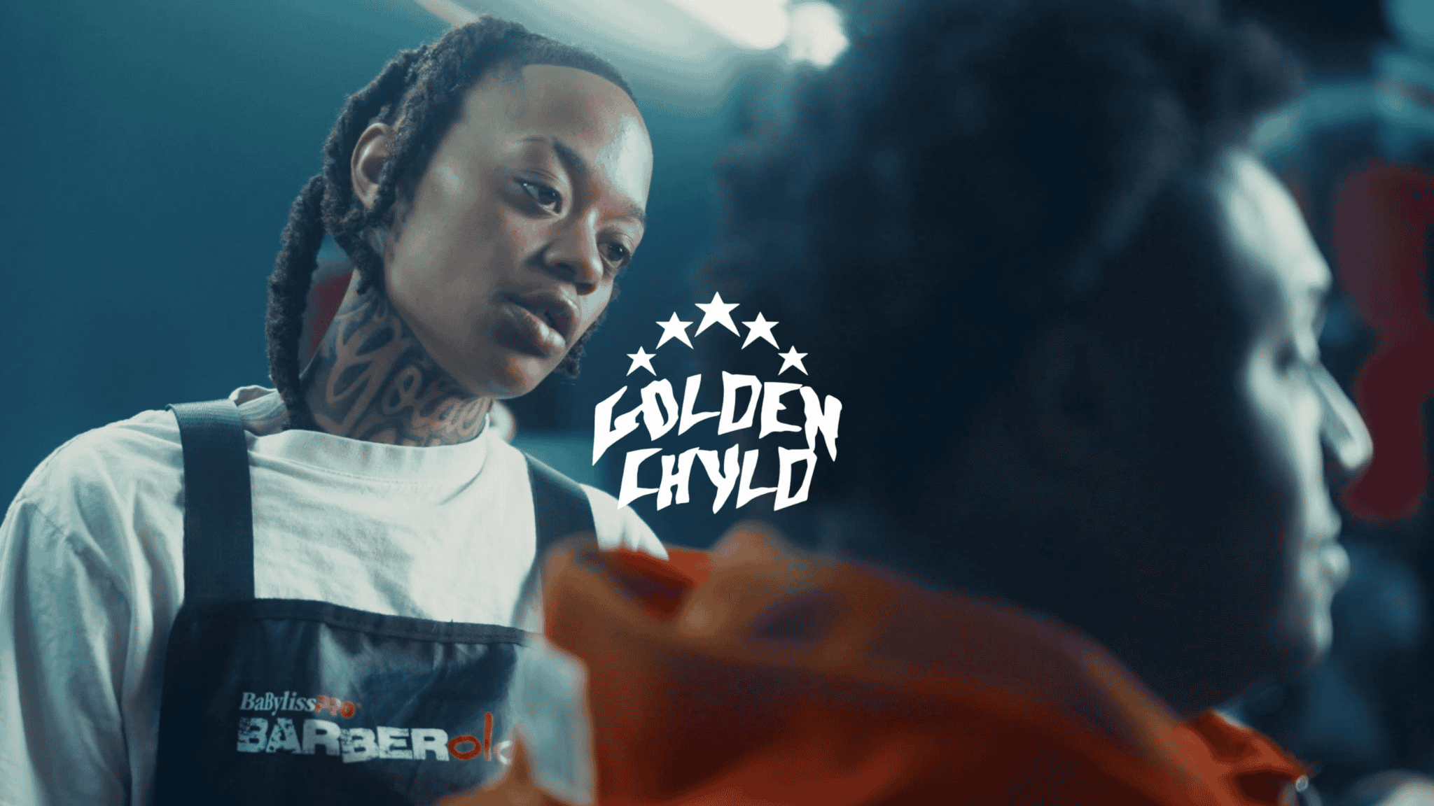 Two tattooed individuals with dreadlocks in a barber shop, one looking at a phone, with 'Golden Crown' logo in the center.