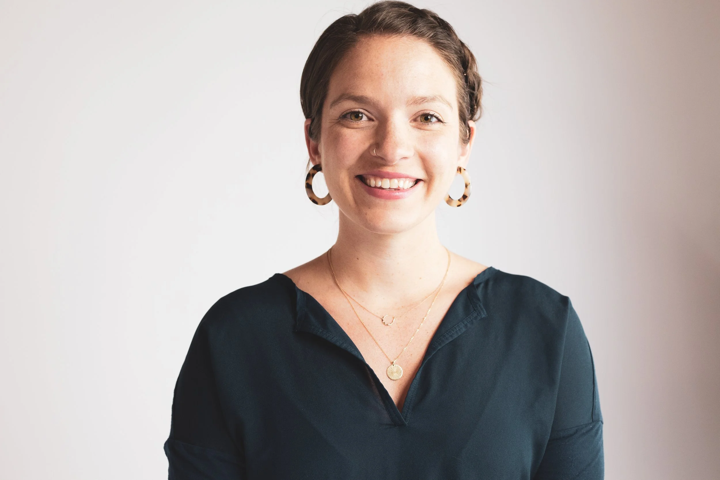Entrepreneur and workplace consultant Hannah Drain Taylor in front of plain background 