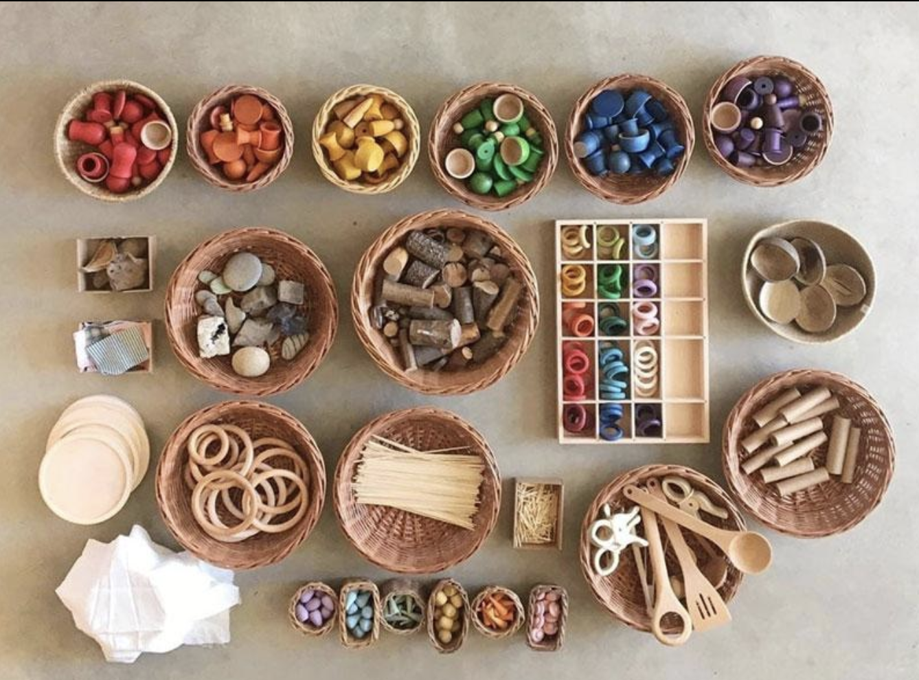 Various craft supplies organized in small baskets and containers, to demonstrate play-based learning