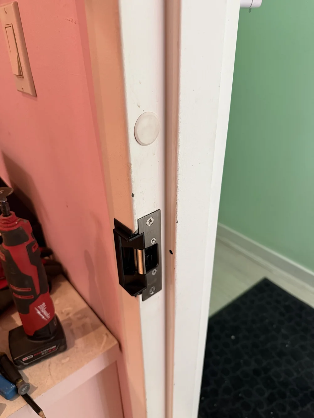 Electric door strike being fitted into a door frame