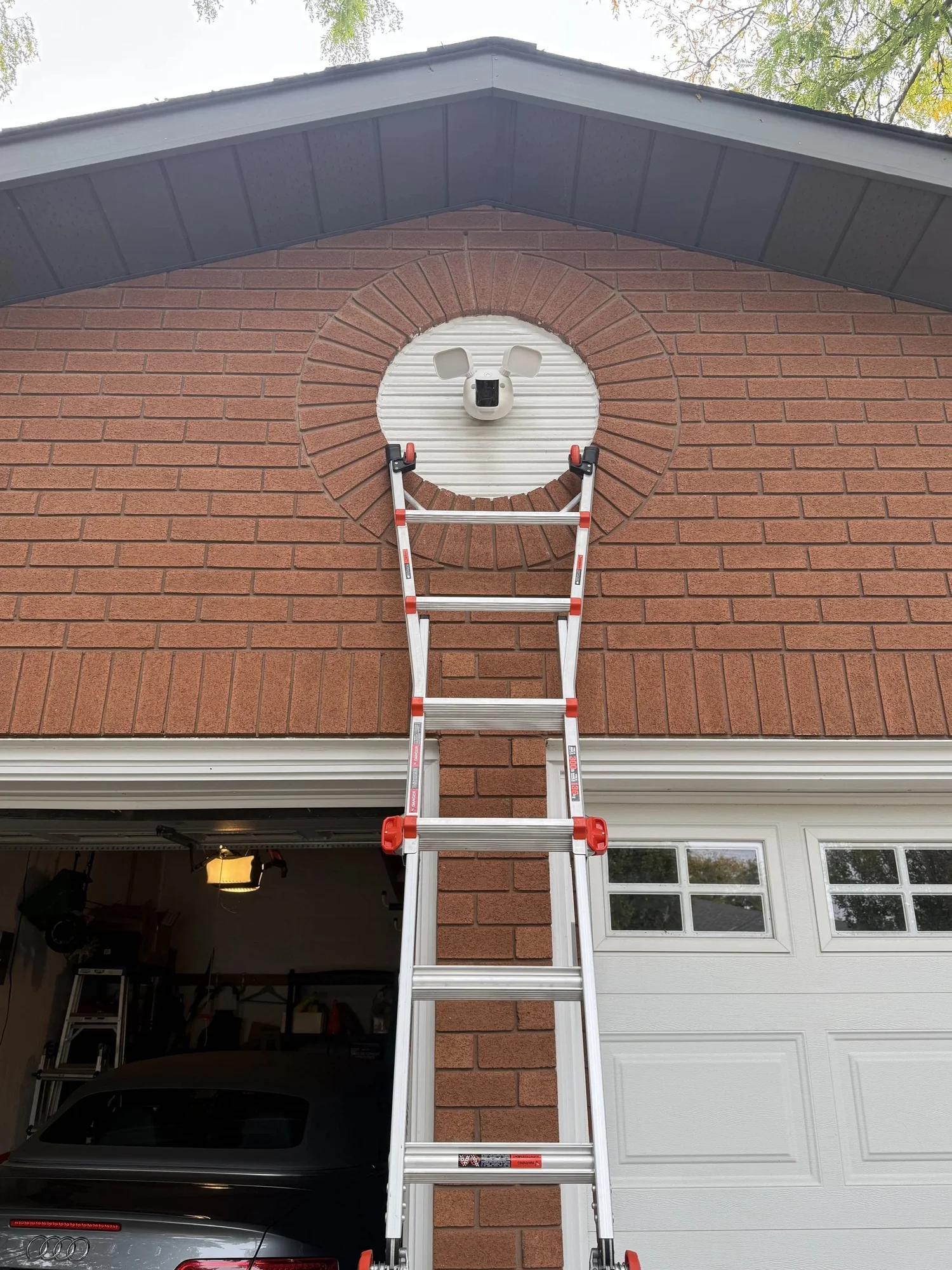 Hutch Security Systems technician ladder set against a brick gable during a camera install