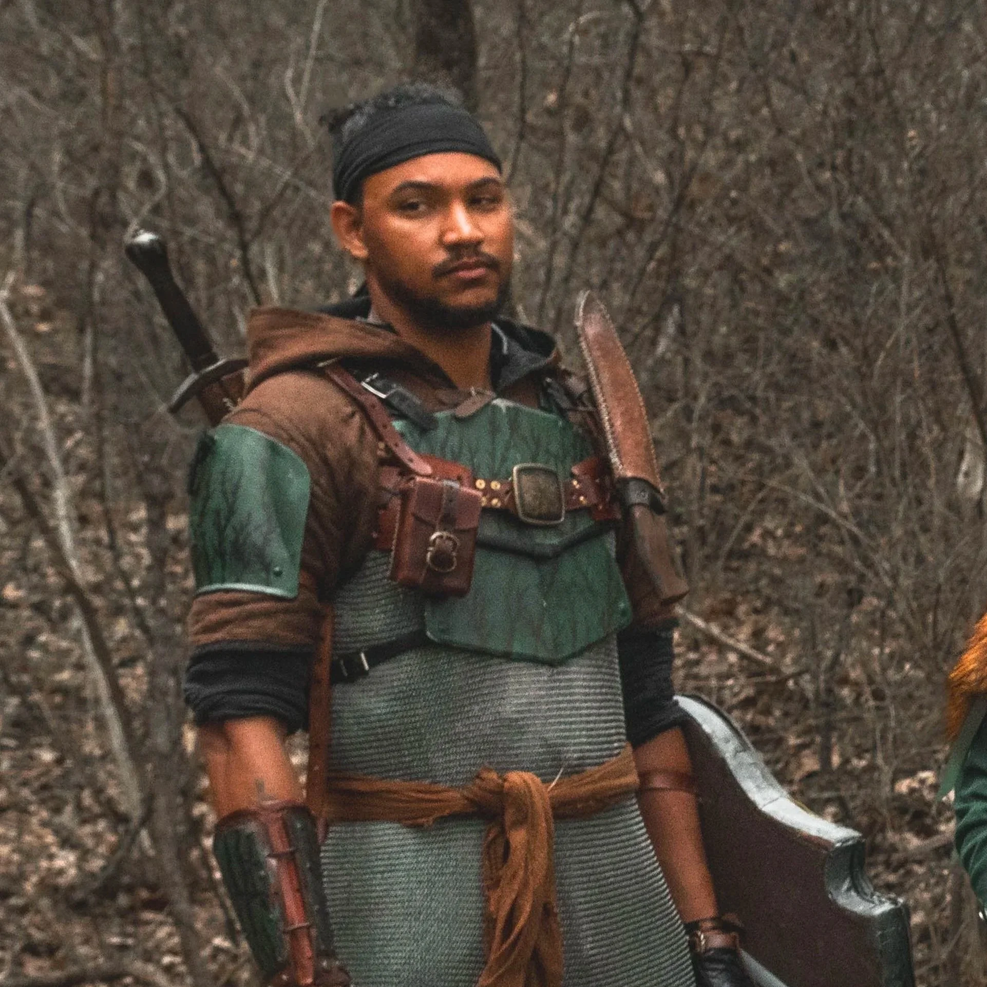 Modern wooden building with large glass window in a mountainous landscape, with a person visible inside.