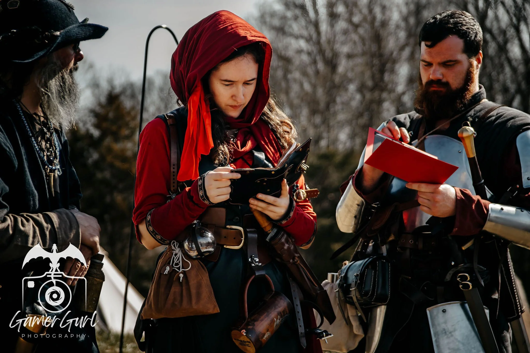 A young woman with curly brown hair and hoop earrings smiling at the camera indoors.