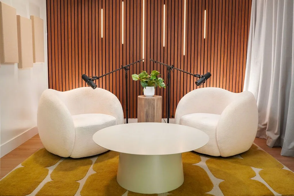 Copenhagen set at Venice Podcast Studio featuring cream bouclé chairs and a round table against a wood slat wall