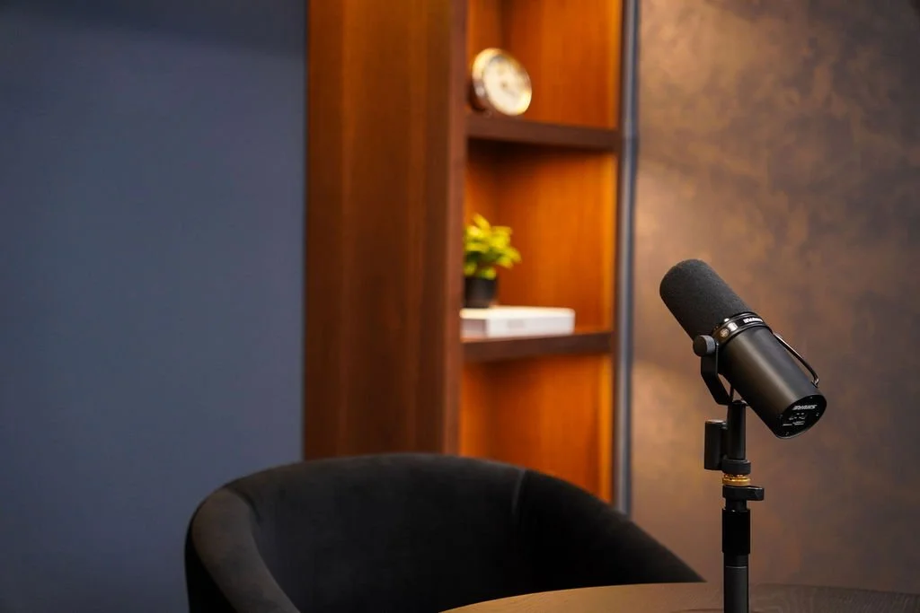 Close-up of a studio microphone and styled bookshelf detail in the Brooklyn set at Venice Podcast Studio
