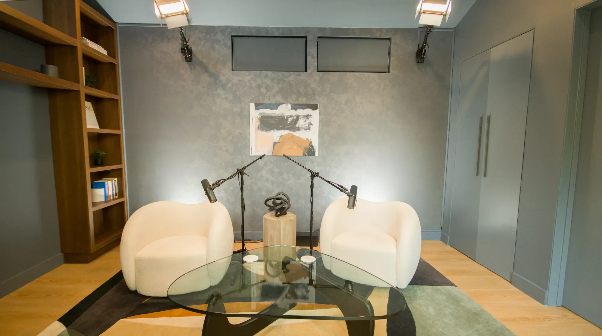 Dark Studio recording room at Venice Podcast Studio featuring moody lighting, built-in shelving, and professional video and audio production equipment in Los Angeles
