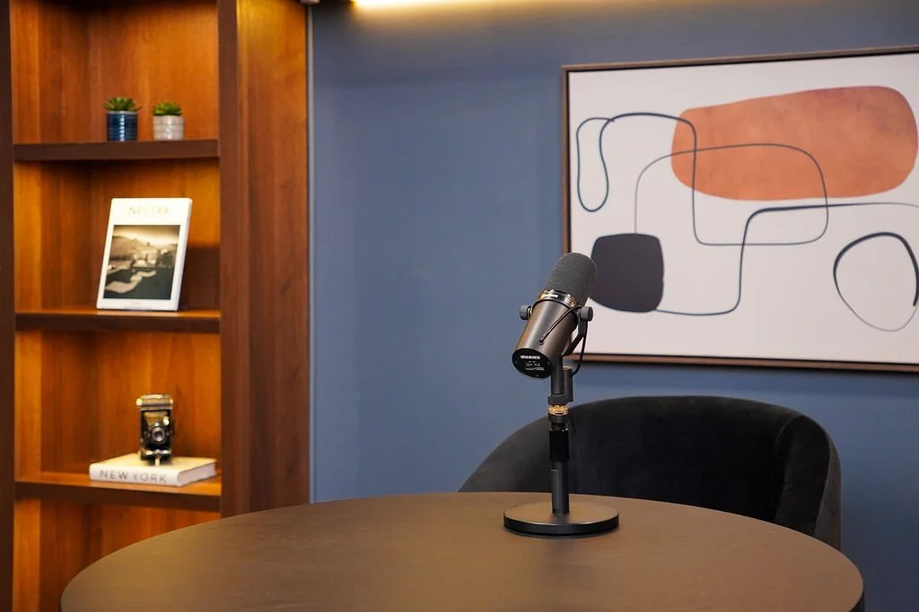 Close-up of a studio microphone and styled bookshelf detail in the Brooklyn set at Venice Podcast Studio