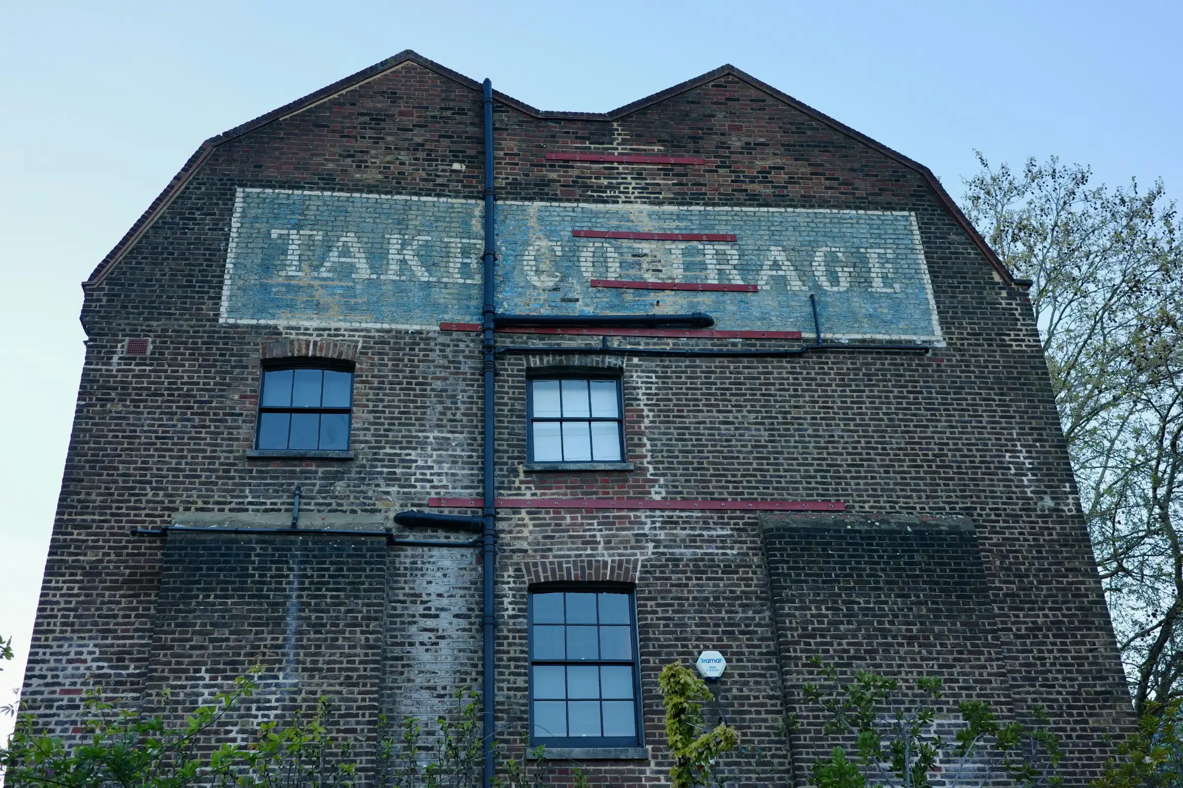 image of a brick warehouse with the words "take courage" painted on the side of the building