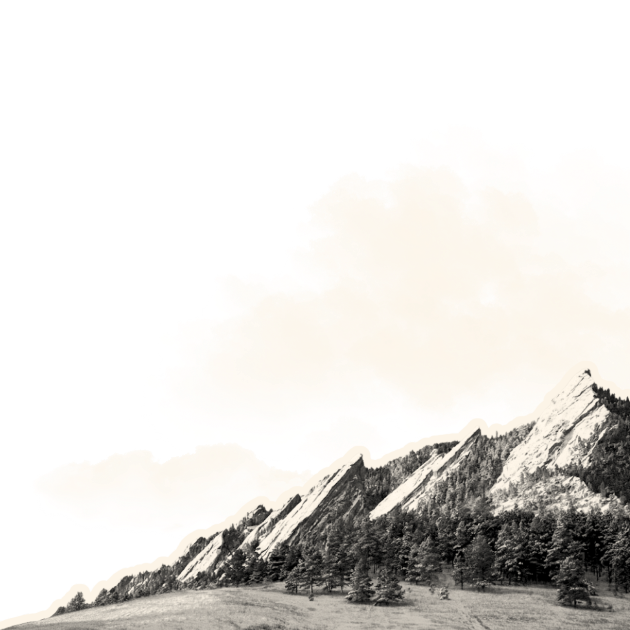 Black and white photograph of a mountain range with trees at the base, and large clouds in the sky.