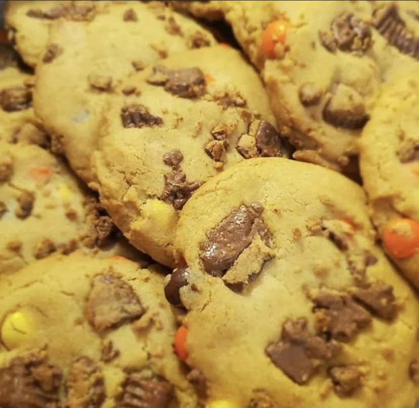 Close-up of chocolate chip cookies with colorful candy pieces.