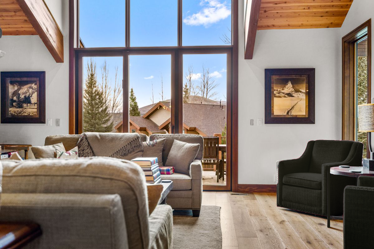PRIMARY BEDROOM WITH RICH WALNUT FURNITURE, GREY TONE CARPETS, SHERLING LOUNGE CHAIR AND IRON LIGHTING