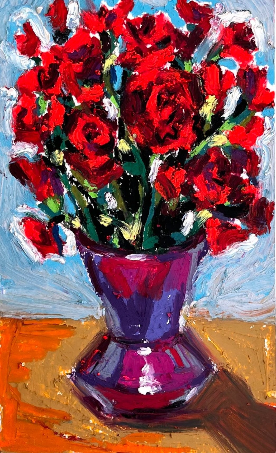 Oil pastel drawing of a vibrant bouquet of red roses in a purple vase on a wooden surface with a light blue background.
