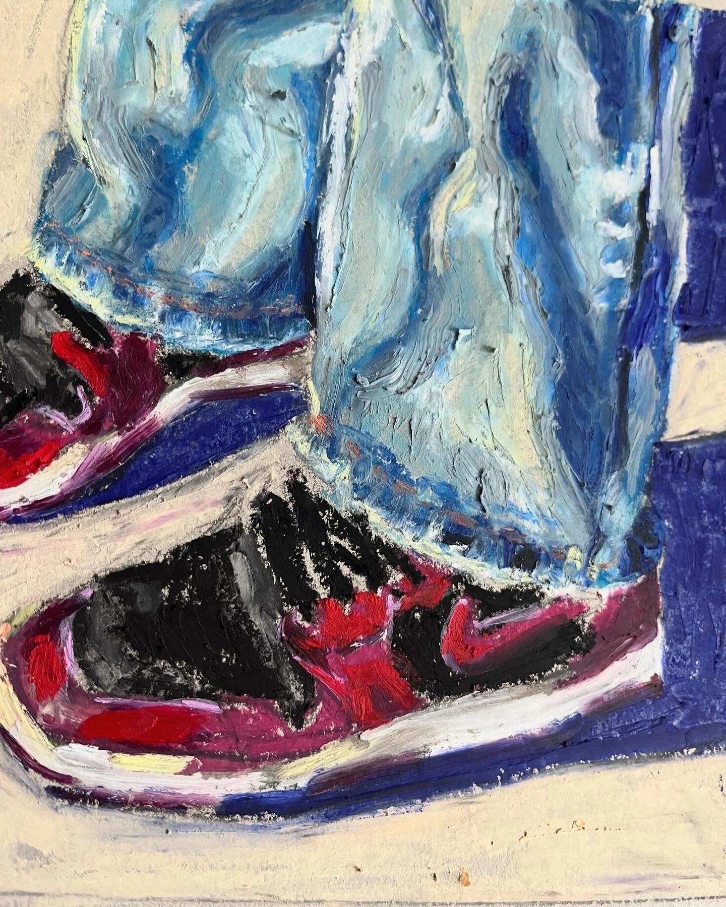 Close-up of a oil pastel drawing of a sneaker with blue jeans, using thick, expressive pastel marks in red, black, beige, and blue.
