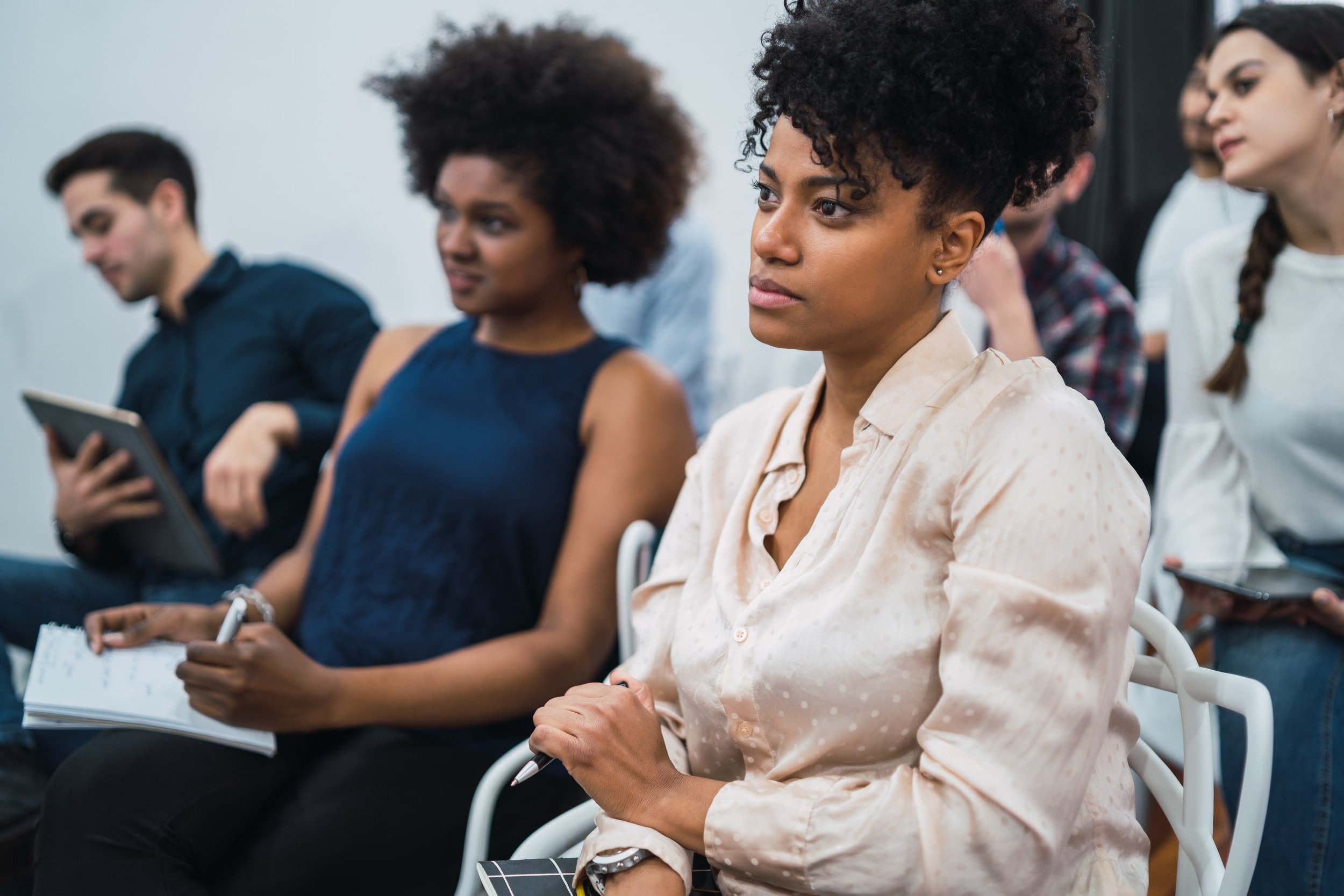 People attentively listening in a classroom or seminar setting.