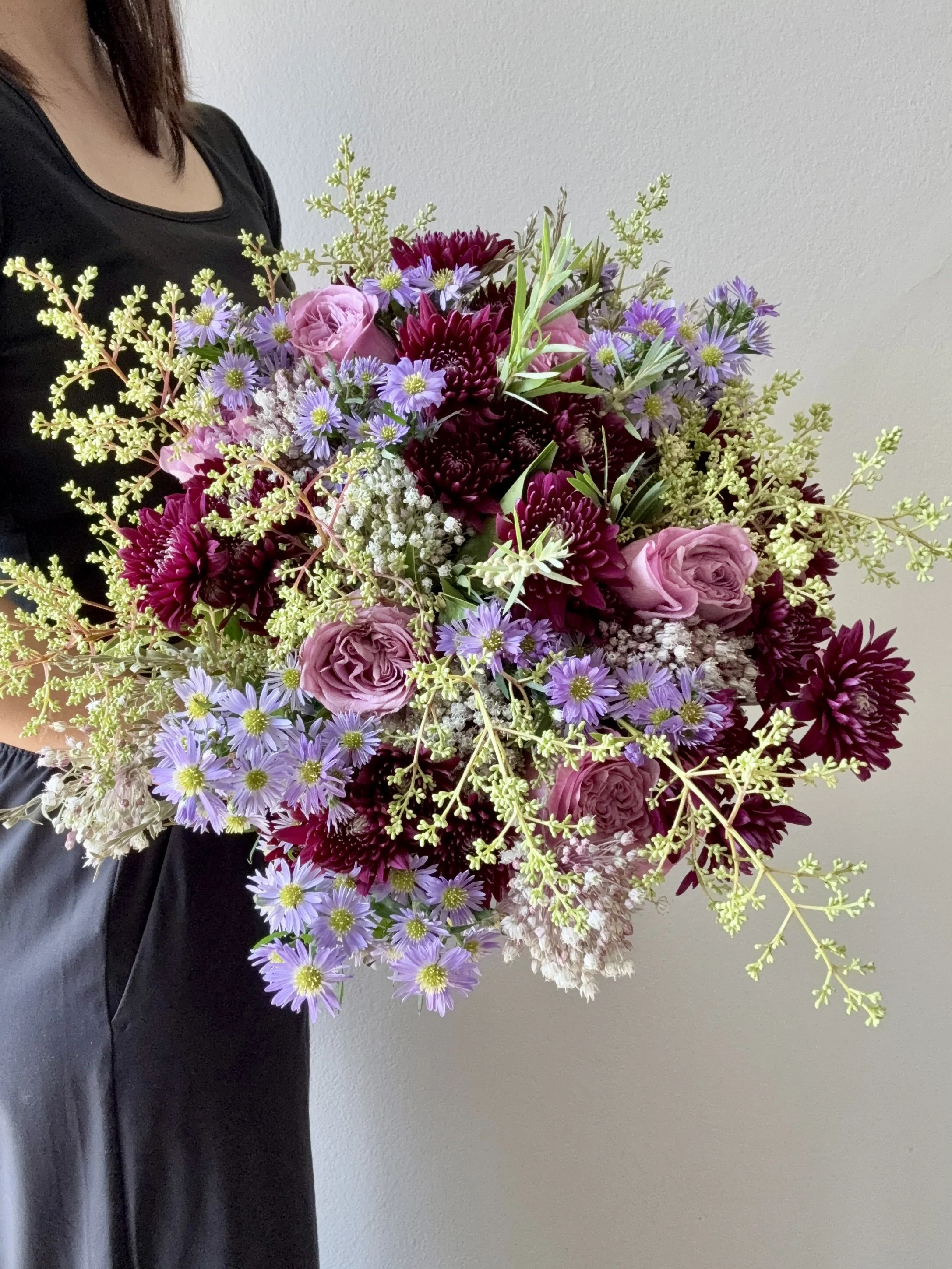 Hand-tied flower bouquet featuring purple aster, burgundy chrysanthemum, and lavender rose