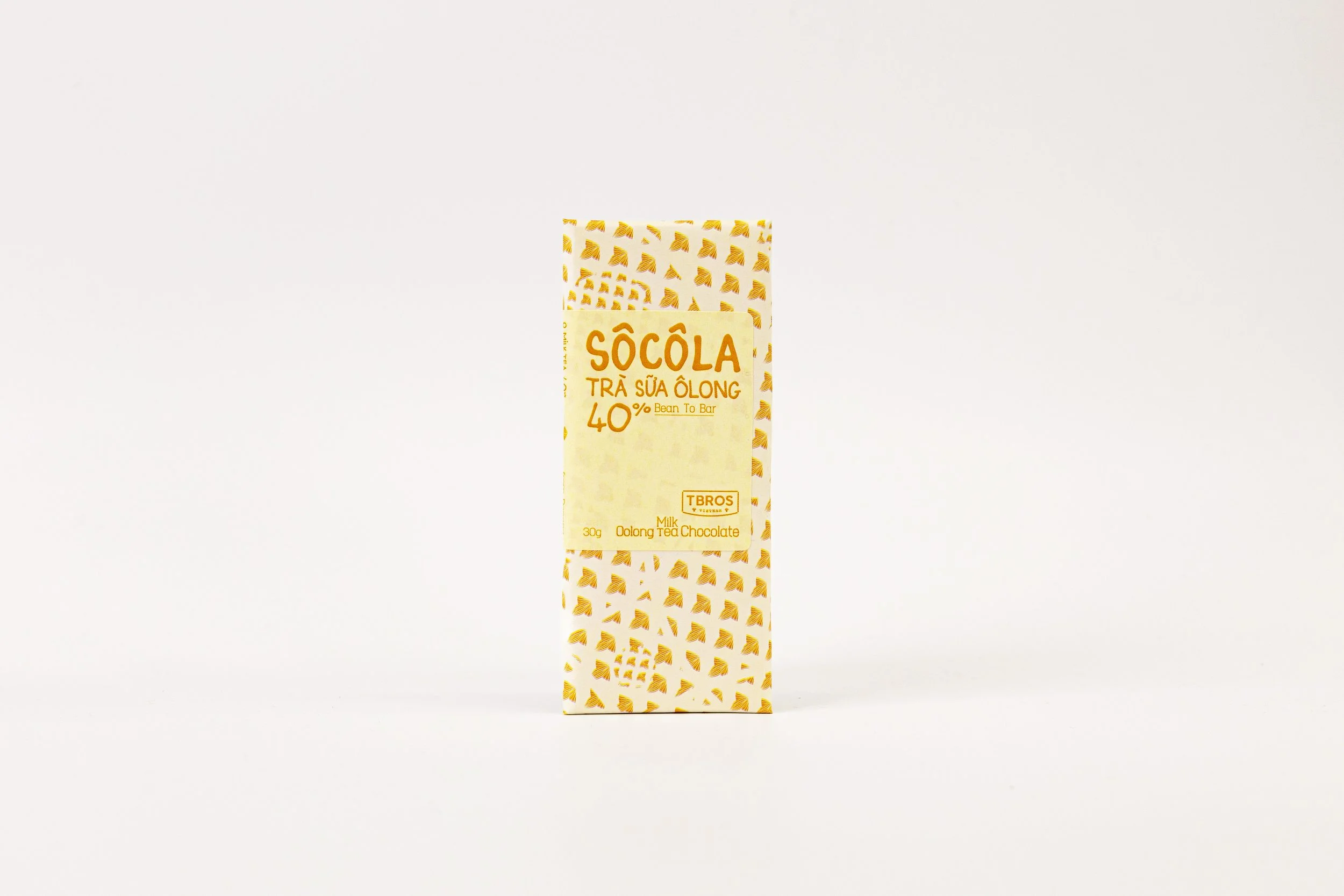 A bar of milk chocolate with a white and yellow wrapper featuring geometric patterns and labeling in Vietnamese and English.