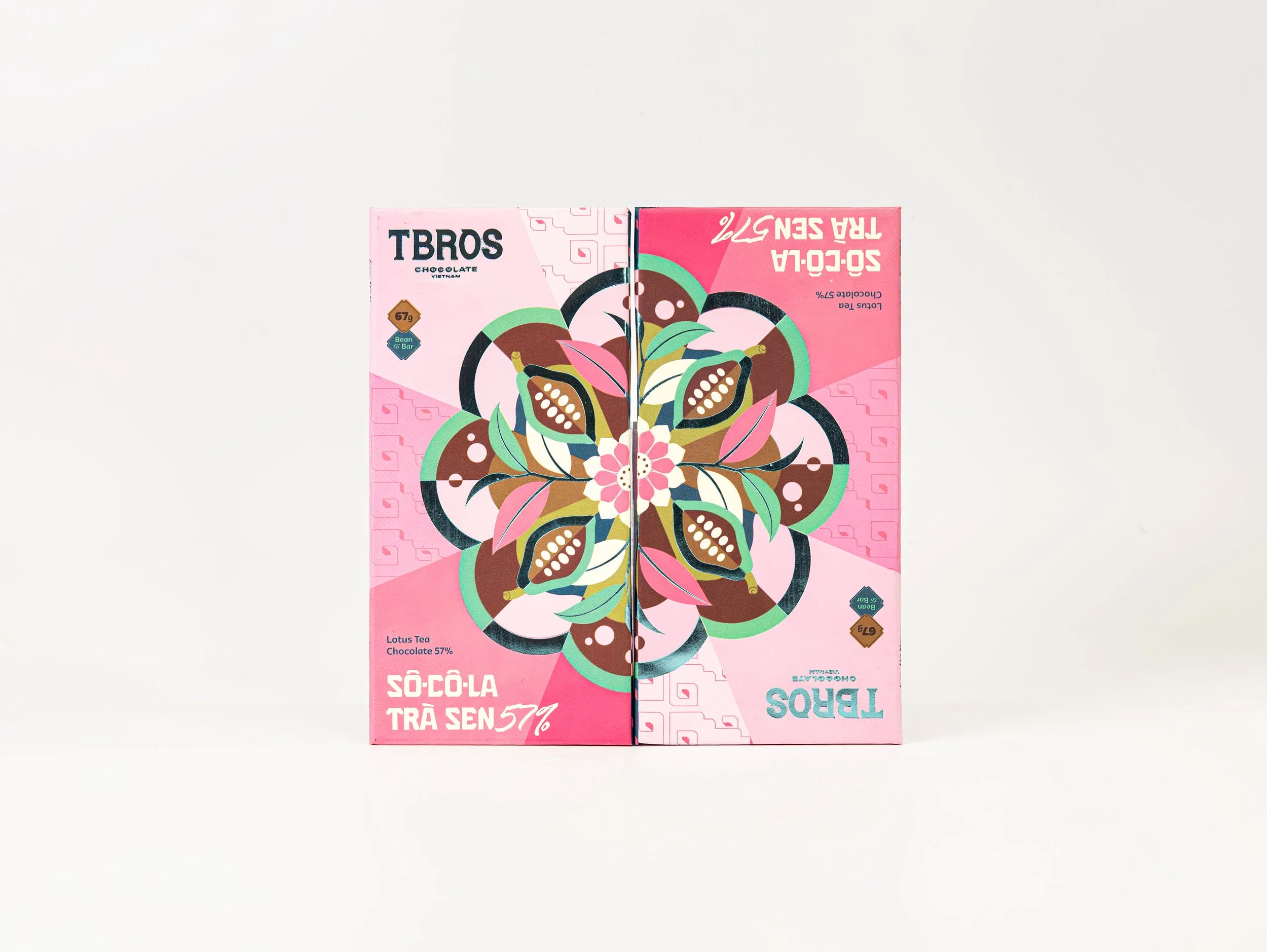 Front view of a pink and colorful box of TBROS chocolate, showing a symmetrical floral pattern with nuts and leaves, placed against a plain white background.